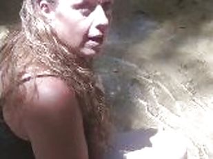 Country Girl Crawling On Her Hands and Knees In Water At Popular Spring Creek