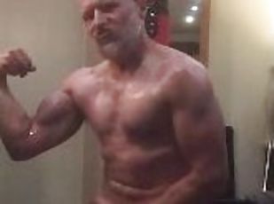 Arrogant muscle Daddy bodybuilder gets turned on flexing his big biceps and oiling up his body