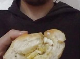 Eating a bread with egg on it